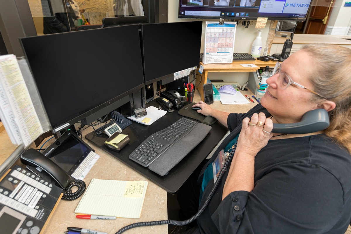 Employee Working At Computers While On Phone Employee Working At Computers While On Phone