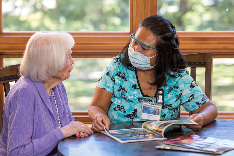 Resident Reading Magazine With Caring Employee Resident Reading Magazine With Caring Employee